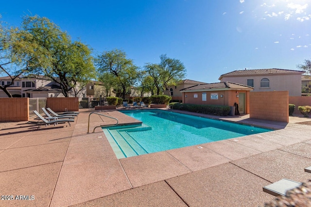 community pool with fence and a patio