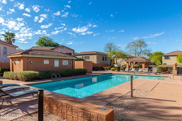 pool featuring a gazebo, a patio area, and fence