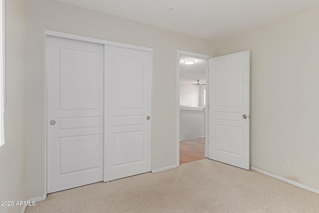 unfurnished bedroom featuring carpet floors, baseboards, and a closet