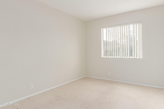 carpeted spare room featuring baseboards