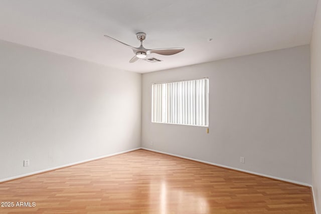 empty room featuring visible vents, light wood finished floors, a ceiling fan, and baseboards