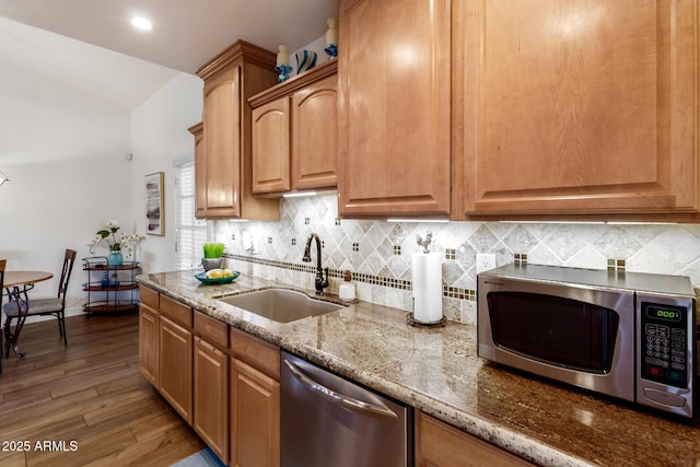 6160 S Pebble Beach Dr, Chandler, AZ 85249 - kitchen featuring appliances with stainless steel finishes, a sink, light stone countertops, tasteful backsplash, and wood finished floors