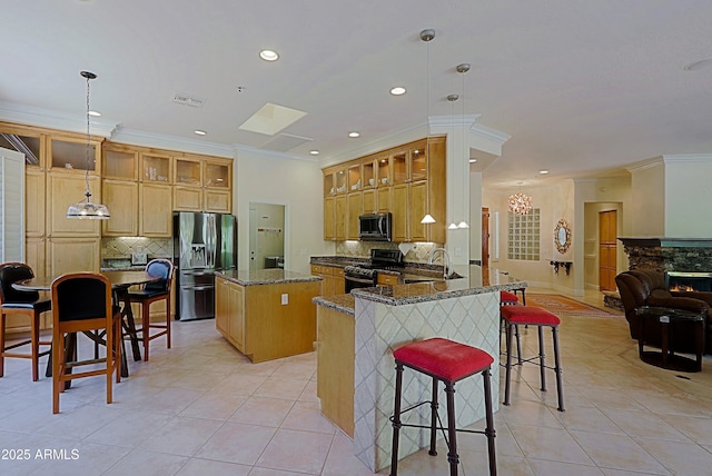 kitchen featuring crown molding, light tile patterned flooring, a center island, tasteful backsplash, and appliances with stainless steel finishes