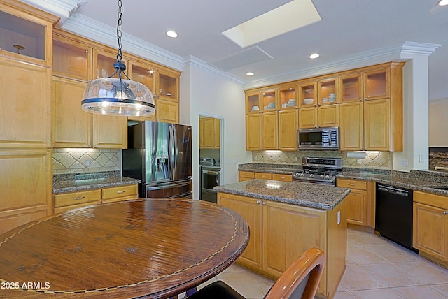 kitchen featuring crown molding, appliances with stainless steel finishes, a center island, and tasteful backsplash