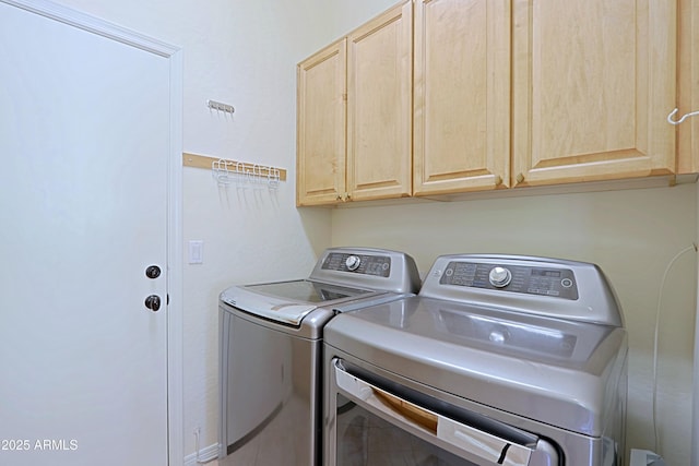 washroom featuring separate washer and dryer and cabinet space
