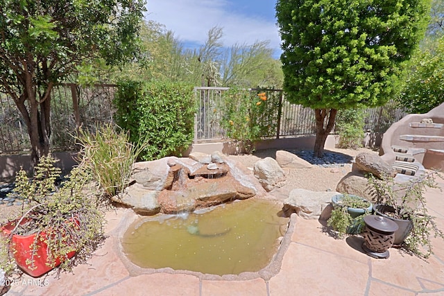 details featuring a fenced backyard and a small pond