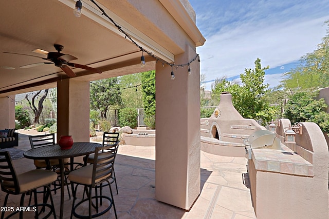 view of patio with an outdoor fireplace, ceiling fan, and outdoor dining space