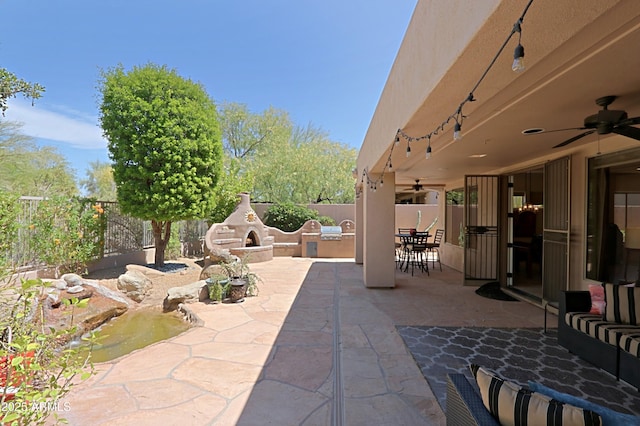 view of patio / terrace with an outdoor kitchen, a ceiling fan, and a fenced backyard