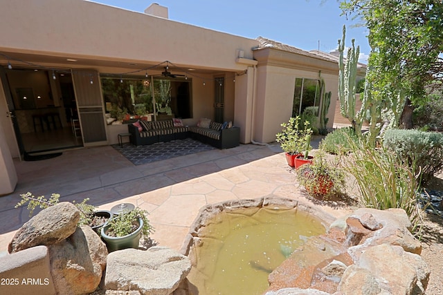 back of property with a patio, ceiling fan, stucco siding, and an outdoor hangout area