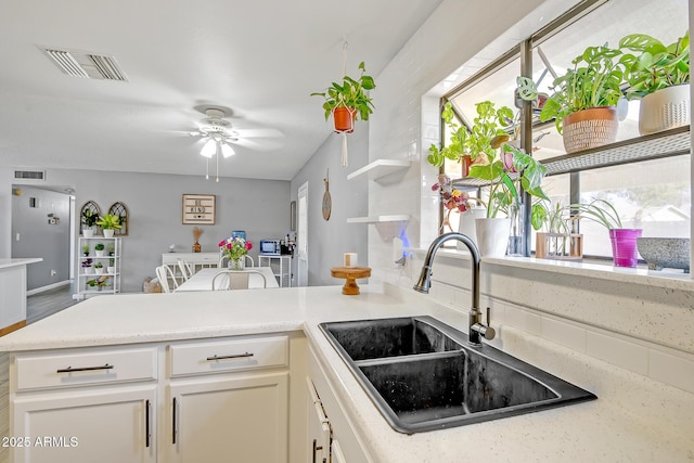 kitchen with a sink, visible vents, light countertops, and a ceiling fan