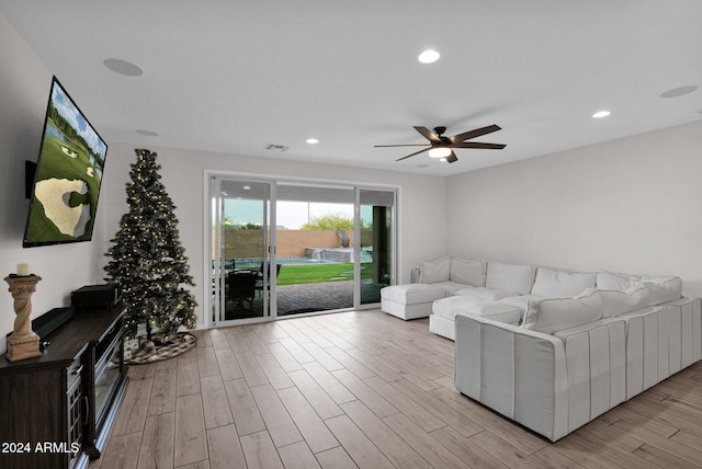 living room with light hardwood / wood-style floors and ceiling fan