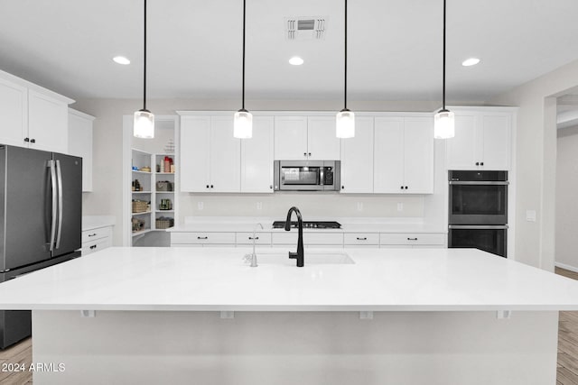 kitchen featuring a sink, visible vents, white cabinets, appliances with stainless steel finishes, and light wood-type flooring