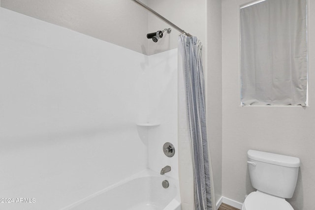 bathroom with toilet and shower / tub combo with curtain