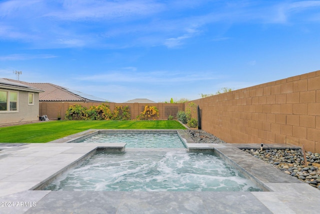 view of swimming pool featuring a lawn and an in ground hot tub