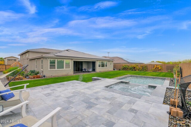 exterior space featuring a patio area, a yard, and an in ground hot tub