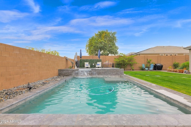 view of pool with pool water feature and a lawn