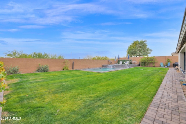 view of yard featuring pool water feature and a fenced in pool