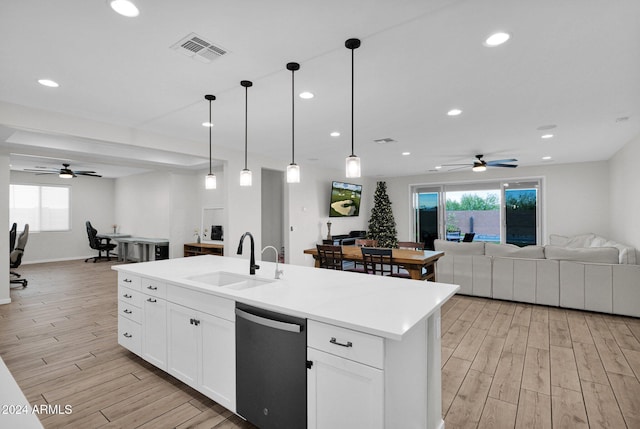 kitchen featuring a center island with sink, ceiling fan, dishwasher, and sink