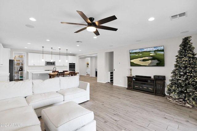 living room featuring light hardwood / wood-style floors and ceiling fan