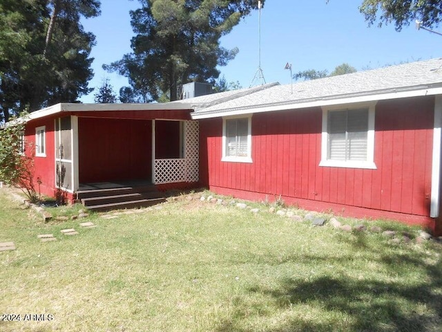 rear view of property featuring a yard