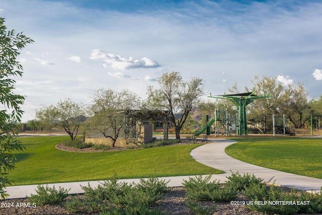 view of property's community with playground community and a lawn