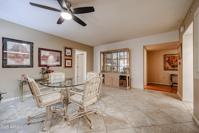 dining space with a textured ceiling and light tile patterned floors