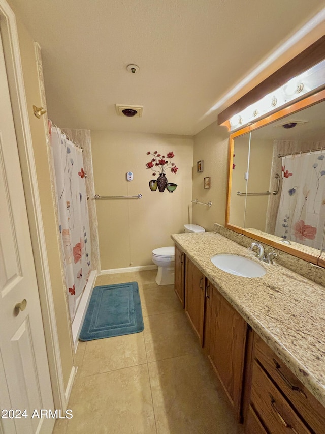 bathroom featuring tile patterned floors, vanity, toilet, and curtained shower