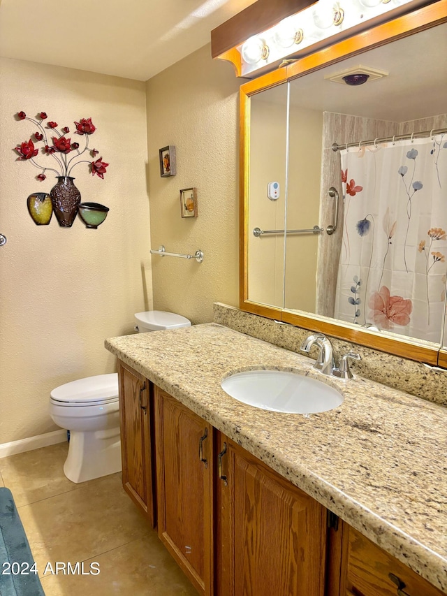 bathroom with tile patterned flooring, vanity, walk in shower, and toilet