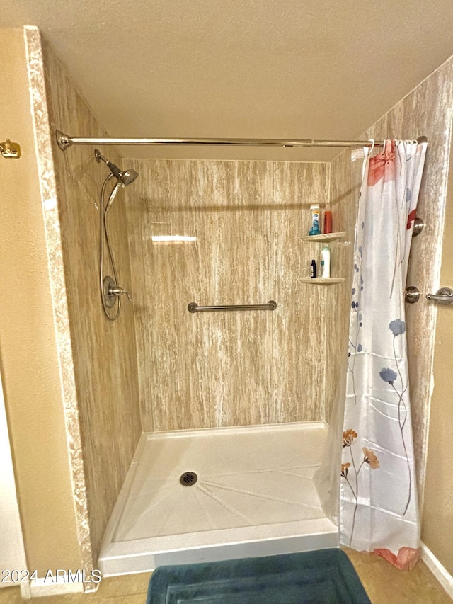 bathroom with curtained shower and a textured ceiling