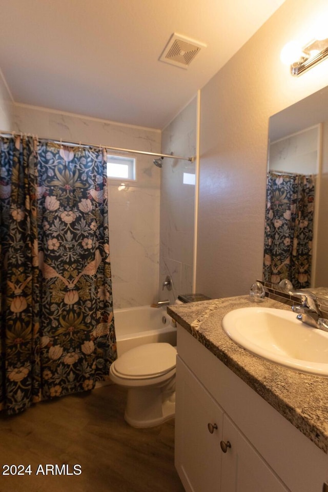 full bathroom with hardwood / wood-style flooring, shower / tub combo with curtain, vanity, and toilet