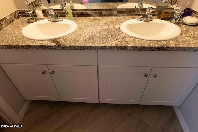 bathroom featuring hardwood / wood-style floors, vanity, and tasteful backsplash