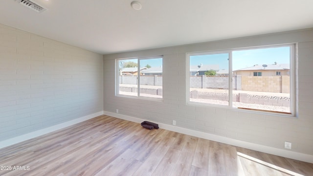 4151 E Clovis Ave, Mesa, AZ 85206 - unfurnished room featuring baseboards, brick wall, light wood-type flooring, and lofted ceiling