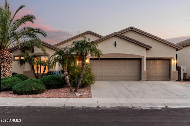 view of front of property with an attached garage, driveway, and stucco siding