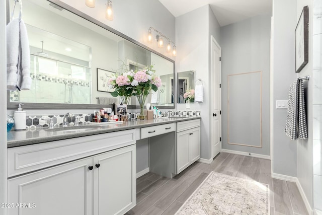 full bathroom with a sink, visible vents, wood finished floors, and double vanity