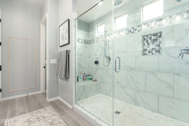 bathroom featuring a shower stall, baseboards, and wood tiled floor