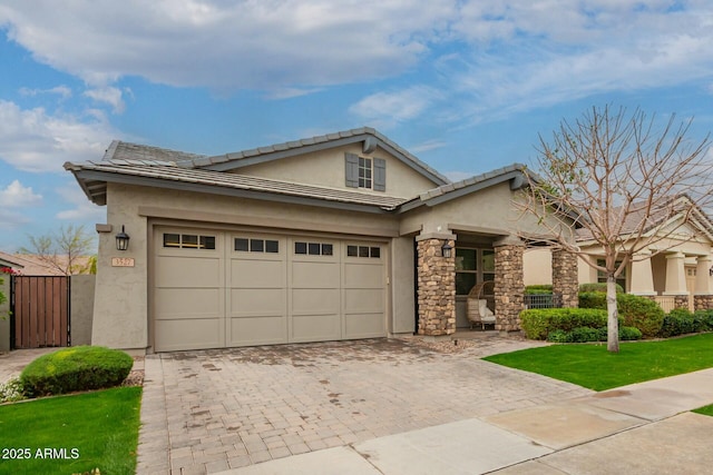 view of front of property featuring decorative driveway, stone siding, a front yard, and stucco siding