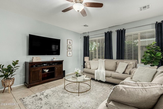 living room featuring baseboards, light tile patterned flooring, visible vents, and a ceiling fan