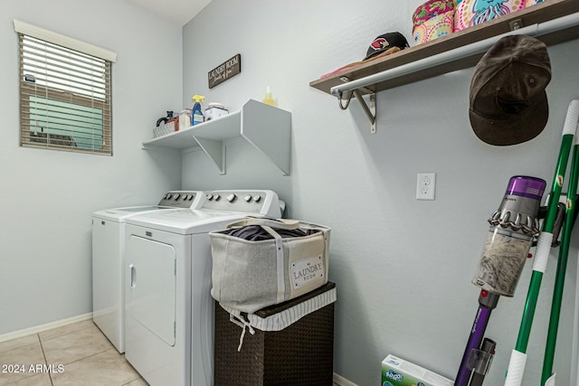 clothes washing area featuring laundry area, light tile patterned floors, baseboards, and washer and dryer