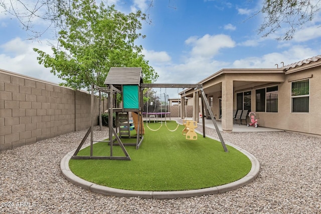 view of playground featuring a trampoline, a patio area, and a fenced backyard