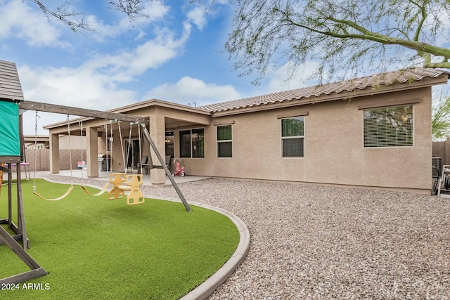 rear view of house featuring a tiled roof, fence, a patio, and stucco siding