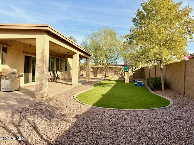 view of yard with a patio area, a playground, and a fenced backyard