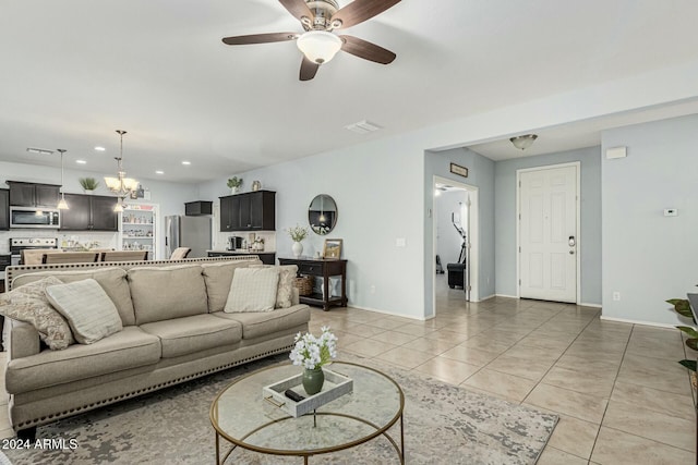 living area featuring light tile patterned floors, baseboards, visible vents, ceiling fan with notable chandelier, and recessed lighting