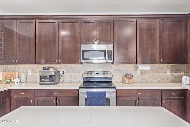 kitchen with appliances with stainless steel finishes and backsplash