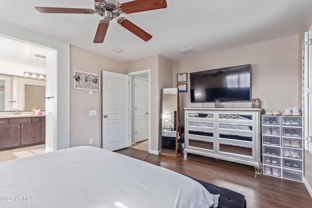 bedroom featuring dark hardwood / wood-style flooring, sink, ensuite bath, and ceiling fan