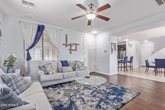 living room featuring hardwood / wood-style floors and ceiling fan