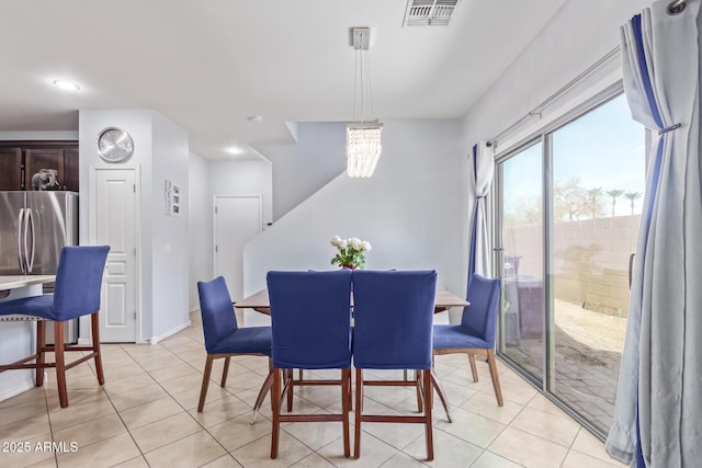 dining area with light tile patterned floors and a chandelier