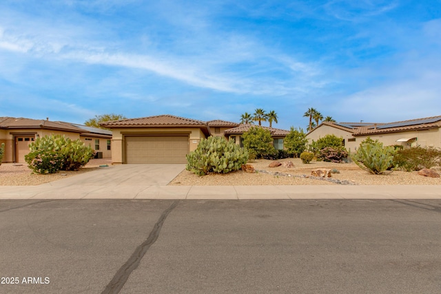 view of front of home featuring a garage, concrete driveway, a tiled roof, and stucco siding