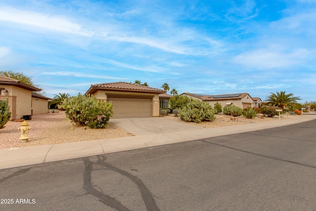 view of front of home with a garage, solar panels, concrete driveway, a tiled roof, and stucco siding