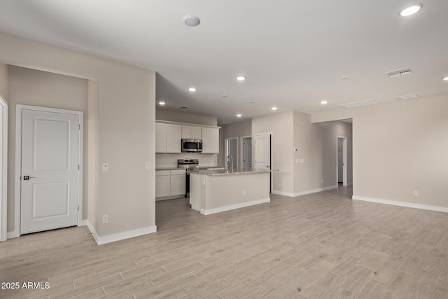 unfurnished living room with sink and light hardwood / wood-style floors