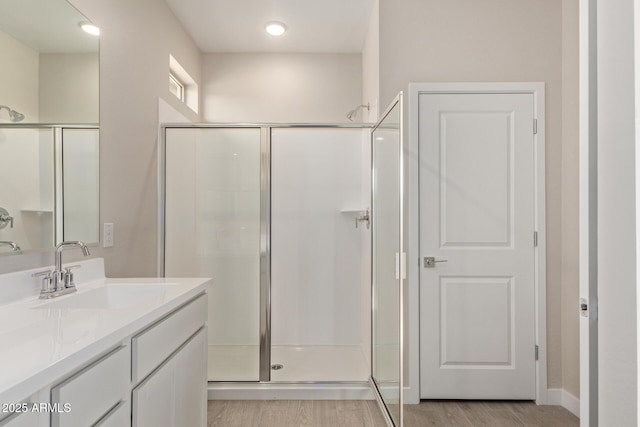 bathroom featuring a shower with door, vanity, and hardwood / wood-style floors